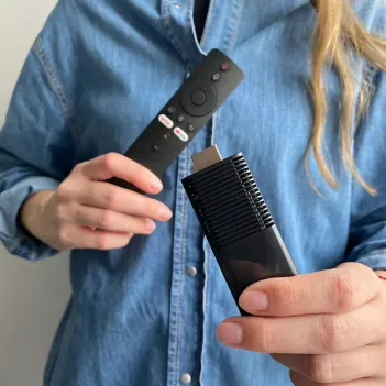 Woman holding remote and streaming stick